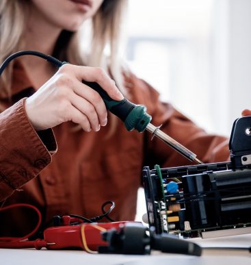 woman repairing electrical appliance at home